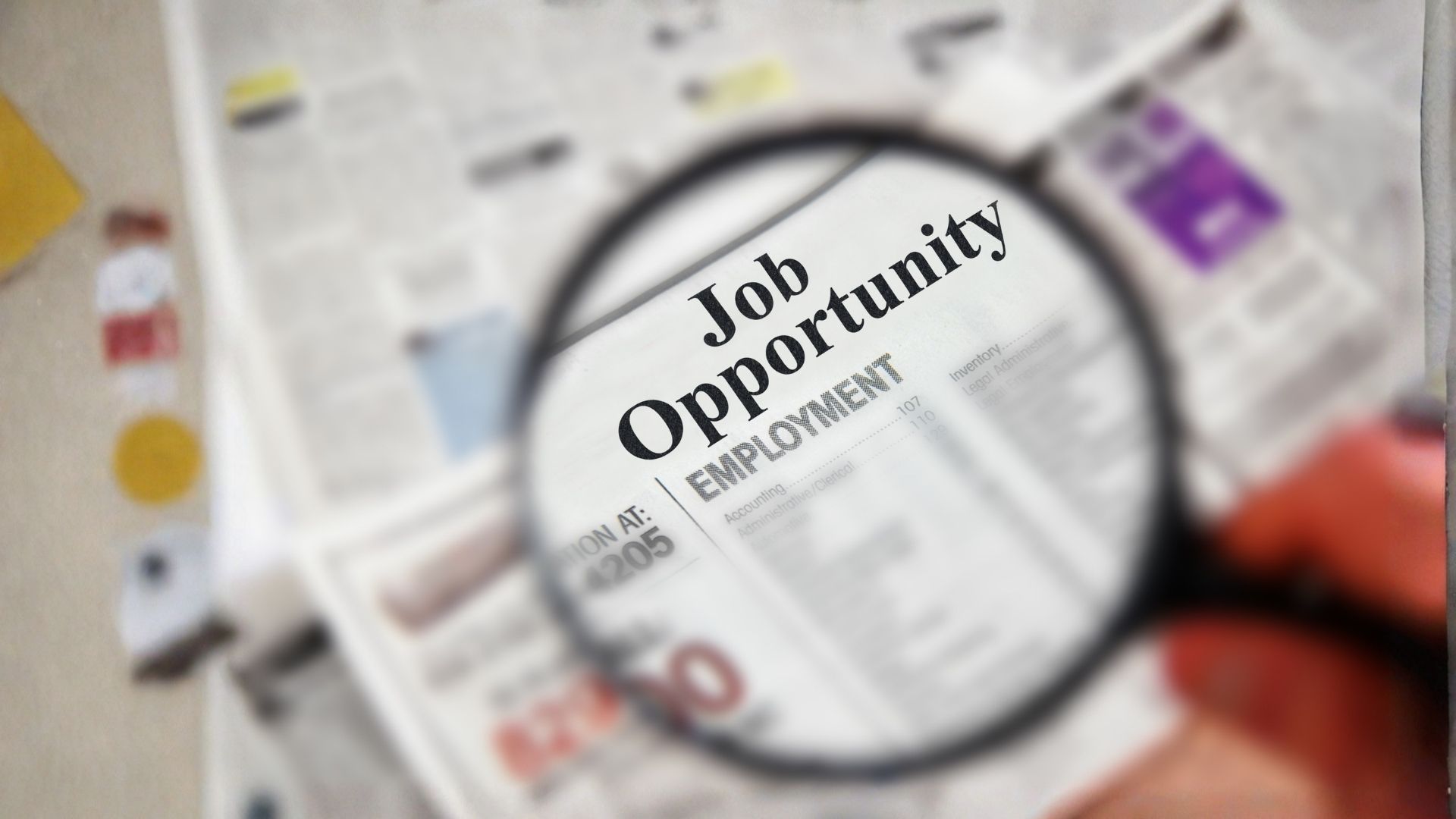 Lente di ingrandimento che evidenzia un'opportunità di lavoro su un giornale