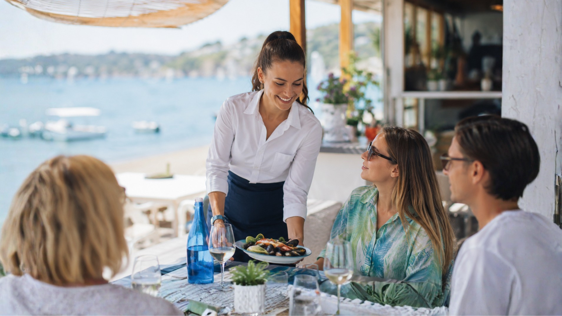 lavoro-stagionale cameriera che serve un piatto di cozze durante un pranzo vista mare